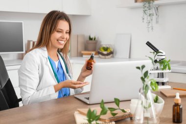 Kadın homeopatik doktor. Ofisteki masada videolu sohbet.