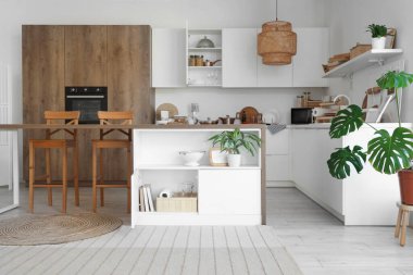 Masası, tezgahı ve dolabı olan modern mutfağın içi.