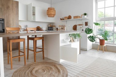 Masası, tezgahı ve dolabı olan modern mutfağın içi.