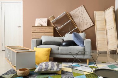 Depremden sonra mobilyaların devrildiği dağınık bir oturma odası.