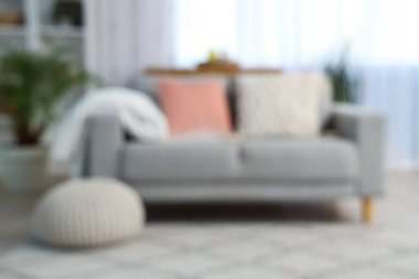 Gri kanepe, pencere ve raf ünitesiyle oturma odasının bulanık görüntüsü