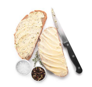 Taze tereyağlı ekmek dilimleri ve beyaz arka planda bir kase biber ve tuz.