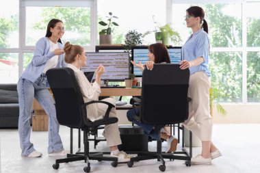 Kadın programcılardan oluşan bir ekip ofiste çalışıyor.