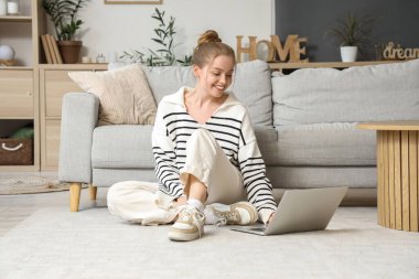 Genç bir kadın evdeki modern bilgisayarı kullanıyor.