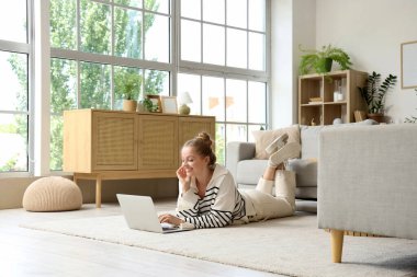 Genç bir kadın evdeki modern bilgisayarı kullanıyor.