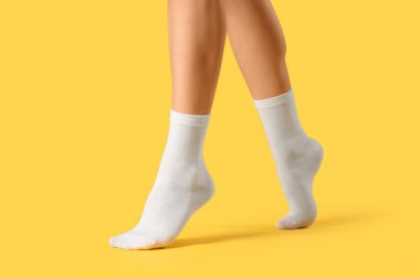 Sarı arka planda beyaz çoraplı kadın, yakın plan.