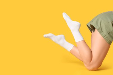 Sarı arka planda beyaz çoraplı kadın, yakın plan.