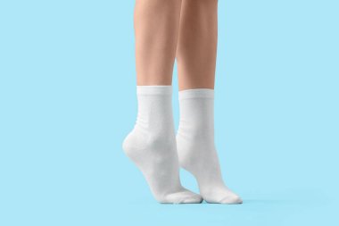 Mavi arka planda beyaz çoraplı kadın, yakın plan.