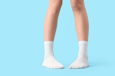 Mavi arka planda beyaz çoraplı kadın, yakın plan.