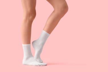 Pembe arka planda beyaz çoraplı kadın.