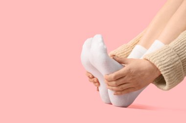 Pembe arka planda beyaz çoraplı kadın, yakın plan.