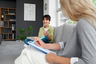 Genç çocuk ofiste psikologla konuşuyor.