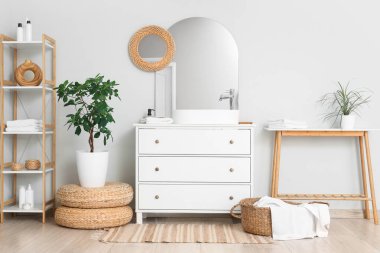 Lavabosu, çekmecesi ve beyaz duvarı olan şık bir banyonun içi.