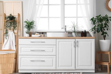 Modern lavabo ve havlular banyo penceresinin yanındaki çekmecelerde.