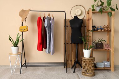 Manken, giysi askılığı ve raf ünitesi olan soyunma odasının içinde.