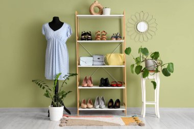 Manken, raf ünitesi ve bitkilerle dolu bir soyunma odası.