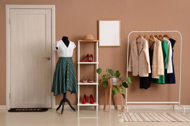 Manken, raf ve giysi rafı olan soyunma odasının içinde.