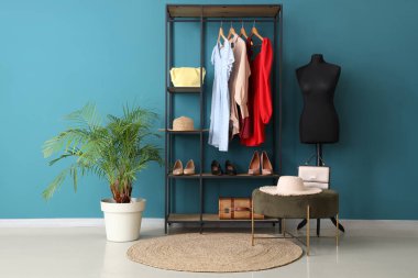 İçinde manken, elbise askılığı ve puf olan soyunma odası.