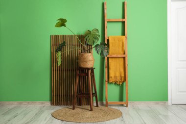 Kahve masası, ev bitkisi, merdiven ve katlanan ekran güzel bir odanın içinde.