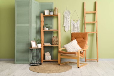 Yumuşak koltuk, raf ünitesi, sehpa ve güzel oturma odasının içindeki katlanır ekran.