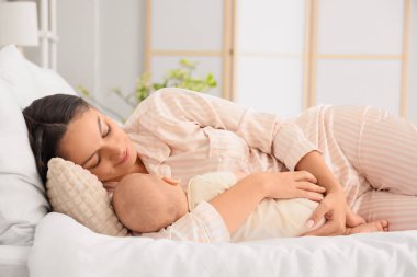 Anne ve uyuyan bebeği yatak odasında yatıyor.