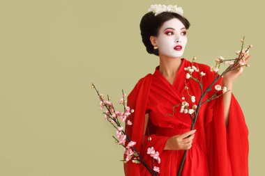 Yeşil arka planda sakura ile güzel genç geyşa