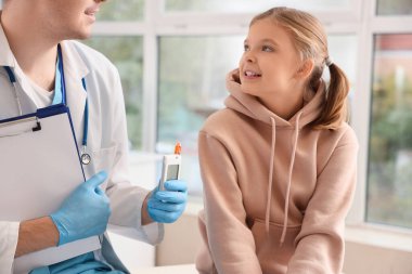 Diyabetli kız klinikte doktoru ziyaret ediyor.