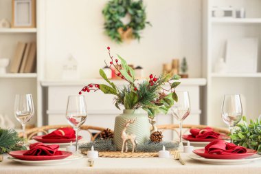 Noel kutlaması için güzel bir sofra, yemek odasında bir vazo kış çiçeğiyle.