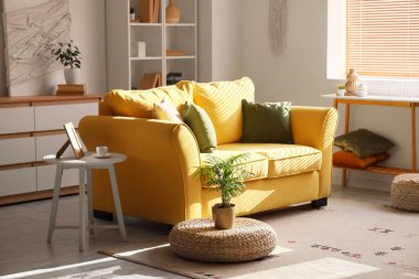 Rahat sarı kanepesi ve çiçekleri olan şık bir oda.