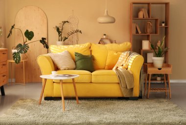 Rahat sarı kanepesi ve sehpası olan şık bir oda.