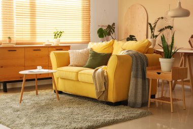 Rahat sarı kanepesi ve sehpası olan şık bir oda.