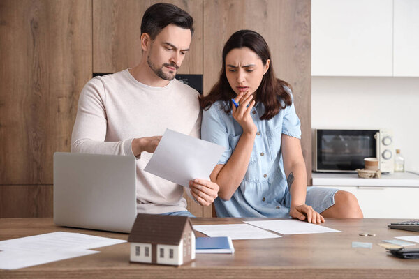 Young couple in debt discussing something at home. Bankruptcy concept