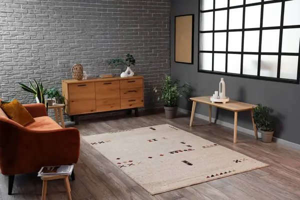 İçinde bej halı, kanepe ve çekmeceler olan oturma odası.