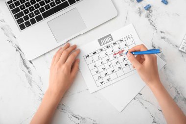 İş yerindeki takvimde son teslim tarihini işaretleyen kadın, üst görünüm