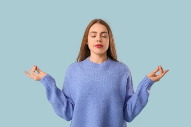 Mavi arka planda meditasyon yapan güzel bir genç kadın. Zen kavramı