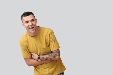 Gri arka planda gülen mutlu genç adamın portresi