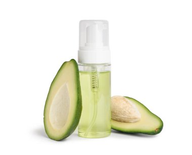 Bir şişe kozmetik ürünü ve beyaz arka planda taze avokado.