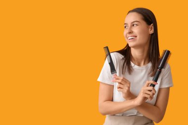 Sarı arka planda fırçası ve tarağı olan kadın kuaför.