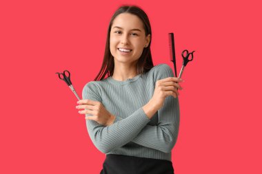 Kırmızı arka planda tarağı ve makasıyla kadın kuaförü.