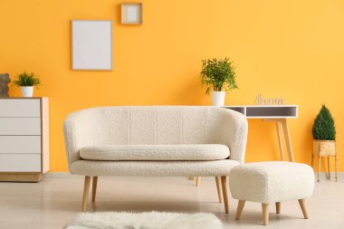 Oturma odasında halı ve ayaklarıyla rahat bir kanepe.