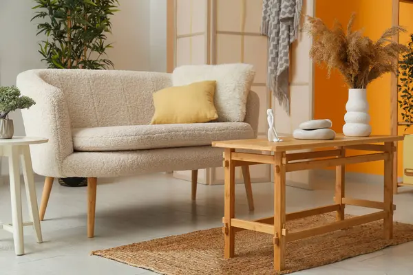 Beyaz rahat kanepe ve oturma odasında süslemeli kahve masası.