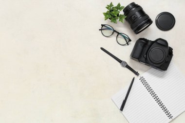 Açık arkaplanda profesyonel fotoğrafçı ekipmanı, gözlük ve kol saati olan kompozisyon