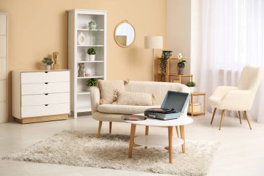 Oturma odasının içinde kanepe, pikabın ve sehpanın üzerinde disketlerin olduğu yer.