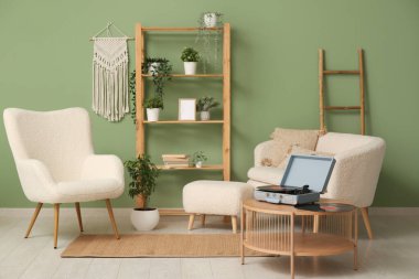 Oturma odasının içinde, sehpada kanepe ve pikap var.