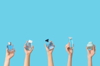 Arka planda mavi parfüm şişeleri olan kadın elleri