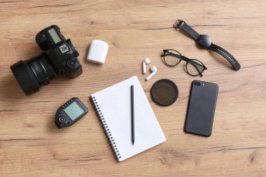 Defterli kompozisyon, modern cihazlar ve ahşap arka planda fotoğrafçı ekipmanı.