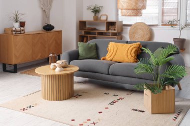 Oturma odası, kanepe, masa ve çekmeceler.