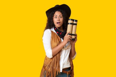 Sarı arka planda dinamiti olan Afro-Amerikalı bir kovboy kız.