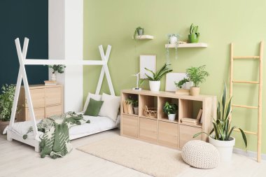 Rahat yatağı ve çiçekleri olan modern çocuk odası.