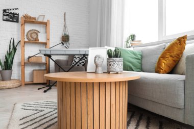 Podcaster 'ın stüdyosunun içinde kanepe ve masa var.